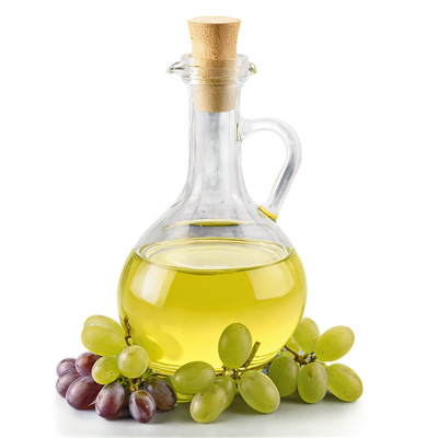 A bottle of grapeseed oil and grapes.